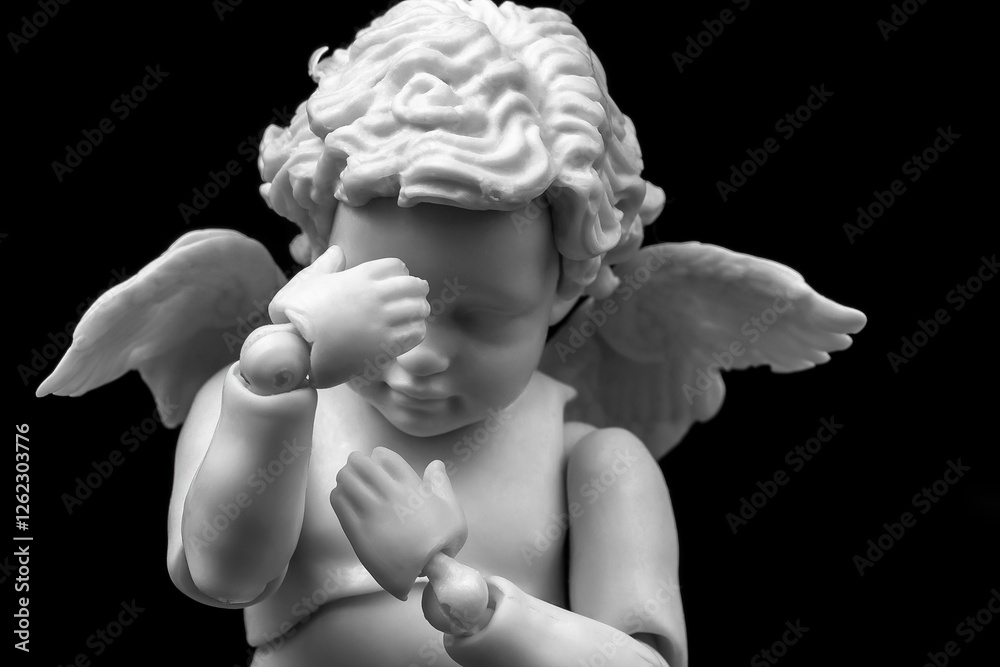 Sad cherub with facepalm gesturing. Angel figurine holding his head in hands on black background Sad cherub with facepalm gesturing. Angel figurine holding his head in hands on black background