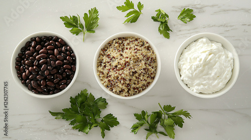 A clean arrangement of cooked quinoa, black beans, and Greek yogurt in individual bowls. photo