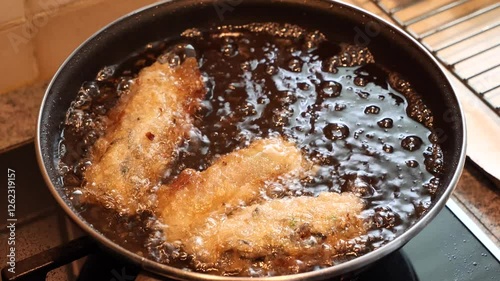 Homemade cooking spring rolls in a frying pan at home
