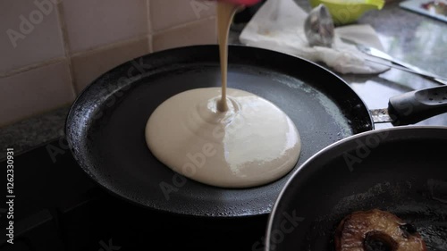 cooking apple fritters in a frying pan in kitchen