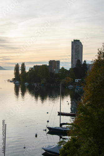 gratte ciel au bord du lac en contre jour, au coucher du soleil