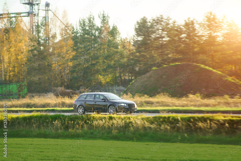 Fototapeta premium Black car on sunny rural road