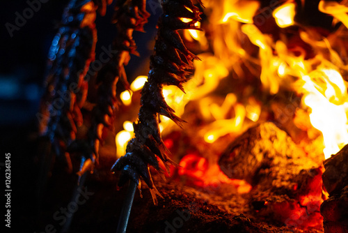 sardines and fish on the fire pierced with a sword, typical of Malaga, they are called espetos