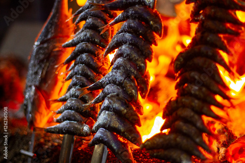 sardines and fish on the fire pierced with a sword, typical of Malaga, they are called espetos
