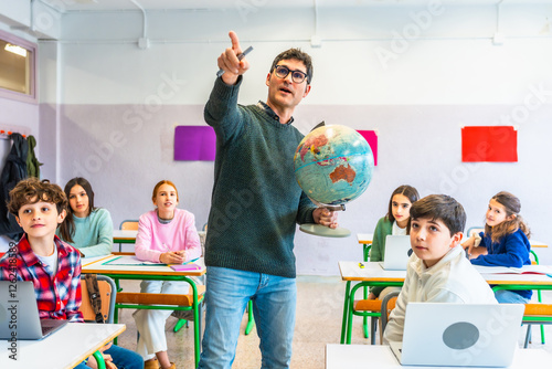 Geography teacher holding globe and pointing at classroom map with students watching photo
