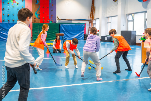 Принти на полотні Elementary school students playing floorball in gym class