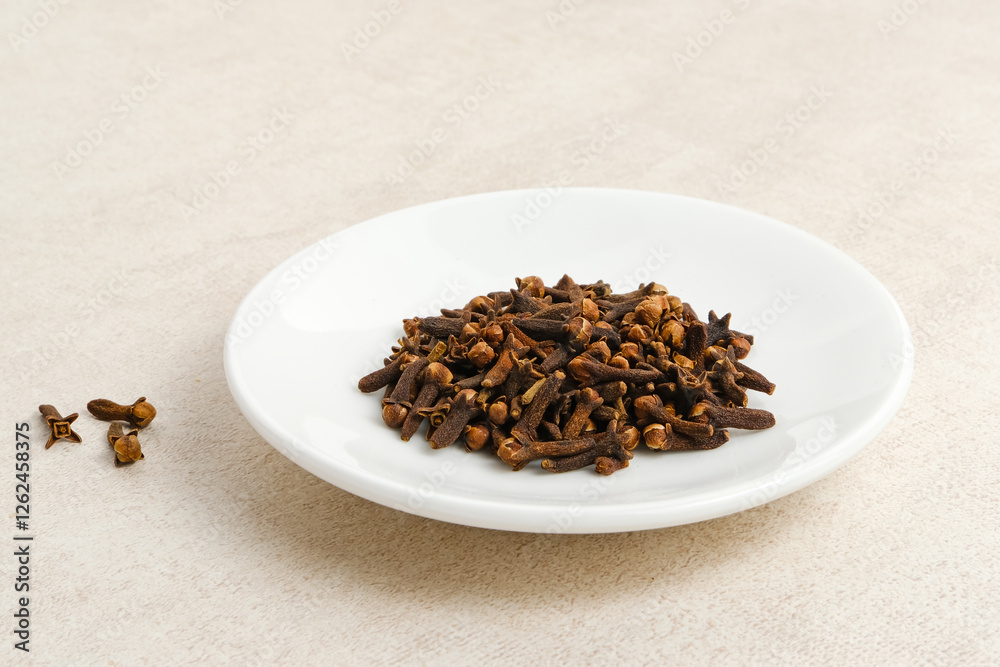 Dried cloves or cengkeh, dried herbs served on white plate
Dried cloves or cengkeh, dried herbs served on white plate
