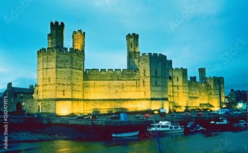  Carnarvon castle at night , Gwynedd, Wales, United Kingdom. Caernarfon Castle seen across the River Seiont.  photo