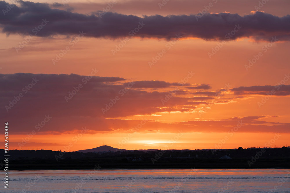 Obraz premium Atardecer de colores vibrantes cerca del Río