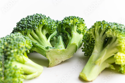 Broccoli, placed on white surface. Nutritional qualities and recipes. photo