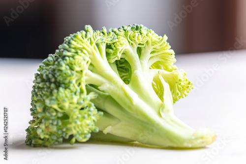 Broccoli, placed on white surface. Nutritional qualities and recipes.