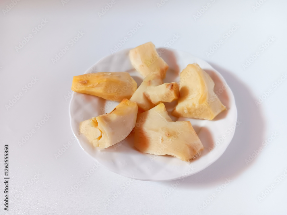 Close up of fresh peeled and cut ginger in a plate isolated on white background.