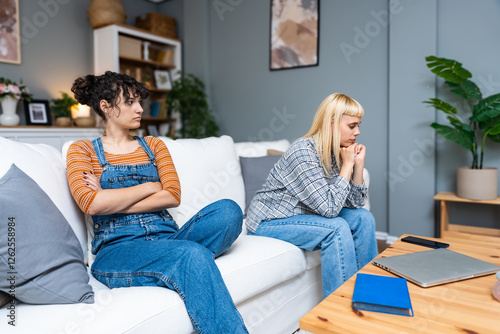 Young gay woman communicating with her girlfriend about problems in their relationship. Lesbian couple relationship difficulties communication problems. Roommates after argue not talking to each other photo