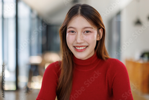 Young Asian business woman smilling with arms crossed at office background