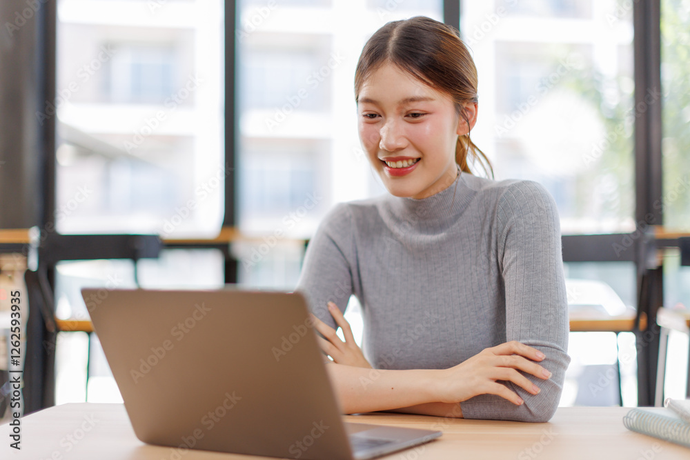 Beautiful young Asian woman working with laptop computer in working space. Work indoor. Remote studying, Virtual training, E-learning, Watching online education, Webinar online Beautiful young Asian woman working with laptop computer in working space. Work indoor. Remote studying, Virtual training, E-learning, Watching online education, Webinar online