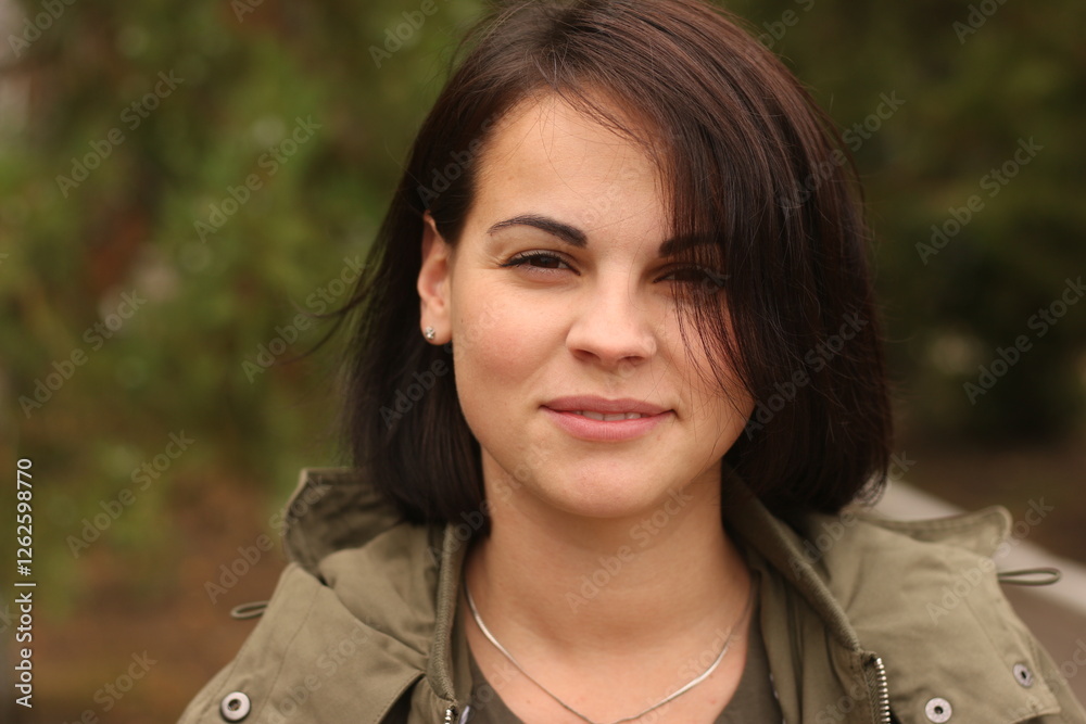 Cute beautiful dark-haired girl in a green jacket in the summer outdoors. Active female leisure concept Cute beautiful dark-haired girl in a green jacket in the summer outdoors. Active female leisure concept