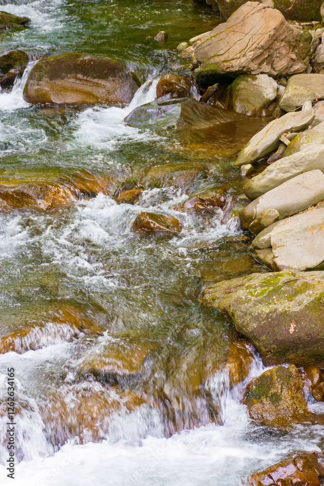 rapid water stream among rocks and stones. beautiful nature background in romanian mountains. closeup view from above
