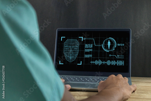 Deepfake and artificial intelligence concept. Man using a laptop to create convincing fake image, video and audio recording.