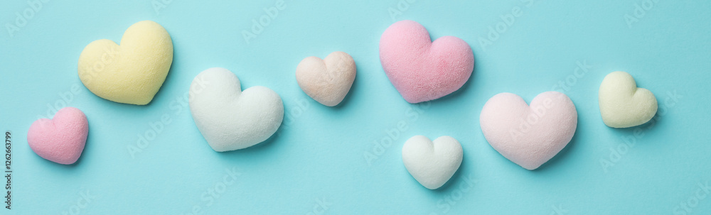 Obraz premium Colorful tiny hearts on pastel blue background. Minimal concept idea. Top view.