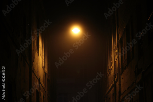 in Bordeaux, a street at night in the fog, illuminated by street lamps, 