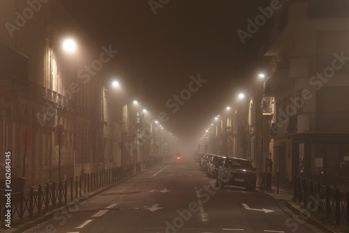  in Bordeaux, a street at night in the fog, illuminated by street lamps