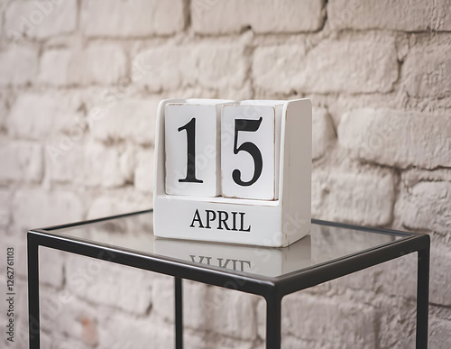 White block wooden calendar present date 15 april with candle and clook