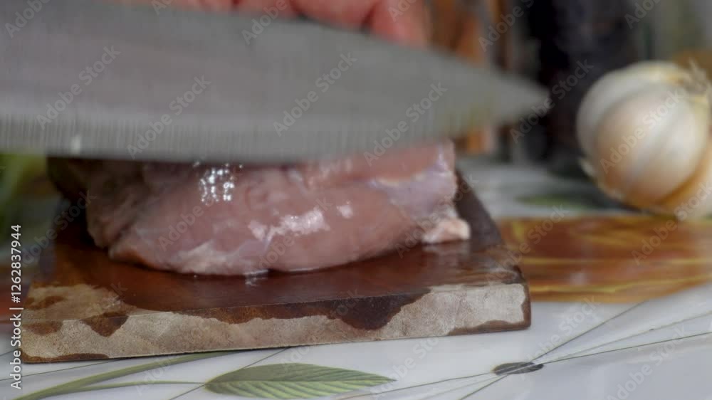 A fresh cut of raw boar meat, sits on a wooden cutting board, ready for preparation and cooking. A fresh cut of raw boar meat, sits on a wooden cutting board, ready for preparation and cooking.