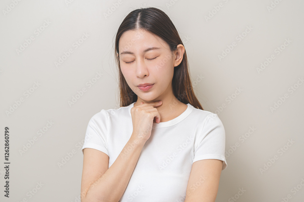Sickness in inflaming asian young woman, girl use hand check self touch at sore throat, pain thyroid gland on neck or disease reflux, acid of suffer people on wall background. Medical and healthcare. Sickness in inflaming asian young woman, girl use hand check self touch at sore throat, pain thyroid gland on neck or disease reflux, acid of suffer people on wall background. Medical and healthcare.