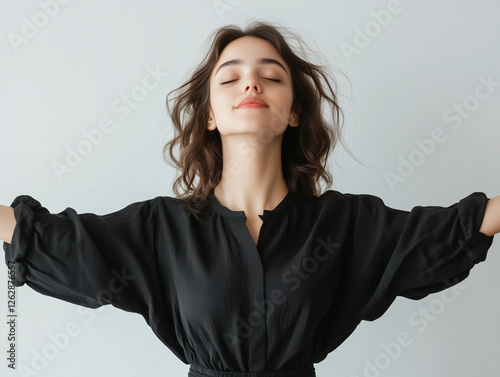 A young confident woman standing with arms outstretched photo