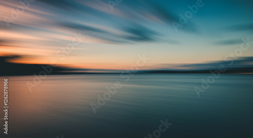 Blurred Sunset over Water, Evoking Serenity. A serene, long exposure image of a sunset over water.