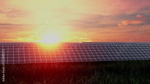 A field of solar panels is illuminated by the sun at sunset. The sky is filled with clouds, creating a moody atmosphere