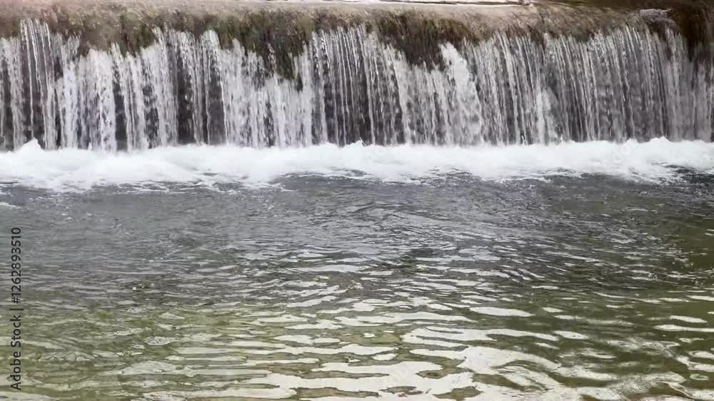 A serene waterfall cascades gently into a clear river, creating rippling patterns on the water’s surface. A serene waterfall cascades gently into a clear river, creating rippling patterns on the water’s surface.