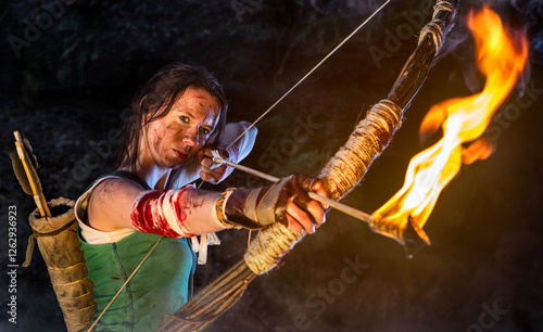 Moody Portrait of a woman warrior with a bow and burning arrow