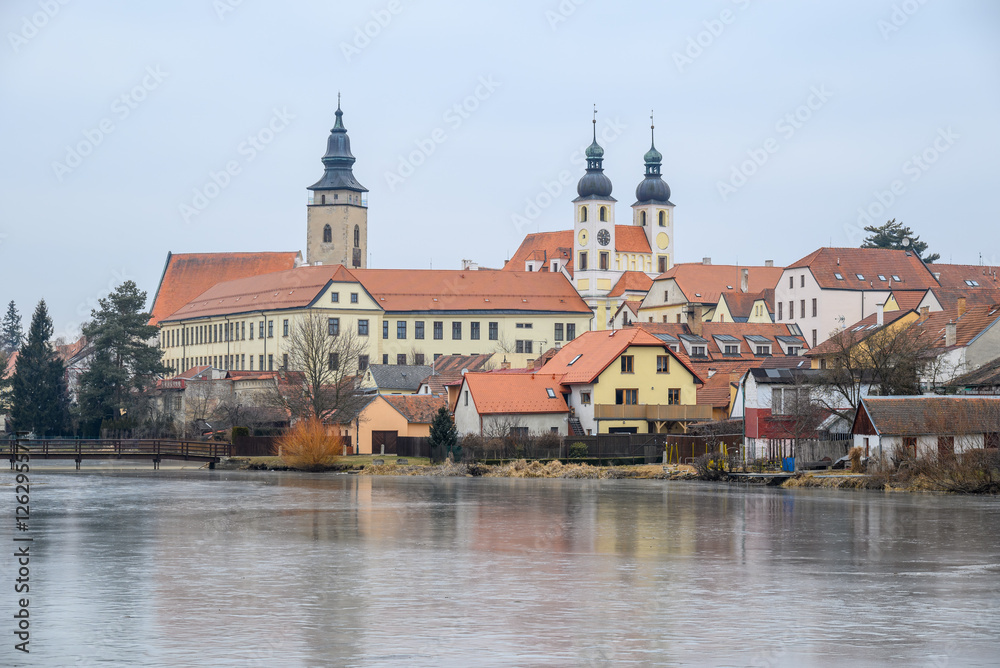 Naklejka premium View of Historic old town of Telc, Unesco World Heritage Site, across frozen Ulicky rybnik pond in winter in Czech Republic