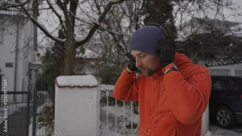 Wallpaper Mural Man finishes his winter run, stops his smartwatch, turns off the music in headphones, opens gate, and enters his homes yard. Snow is falling, and he catches his breath after the workout.  Torontodigital.ca
