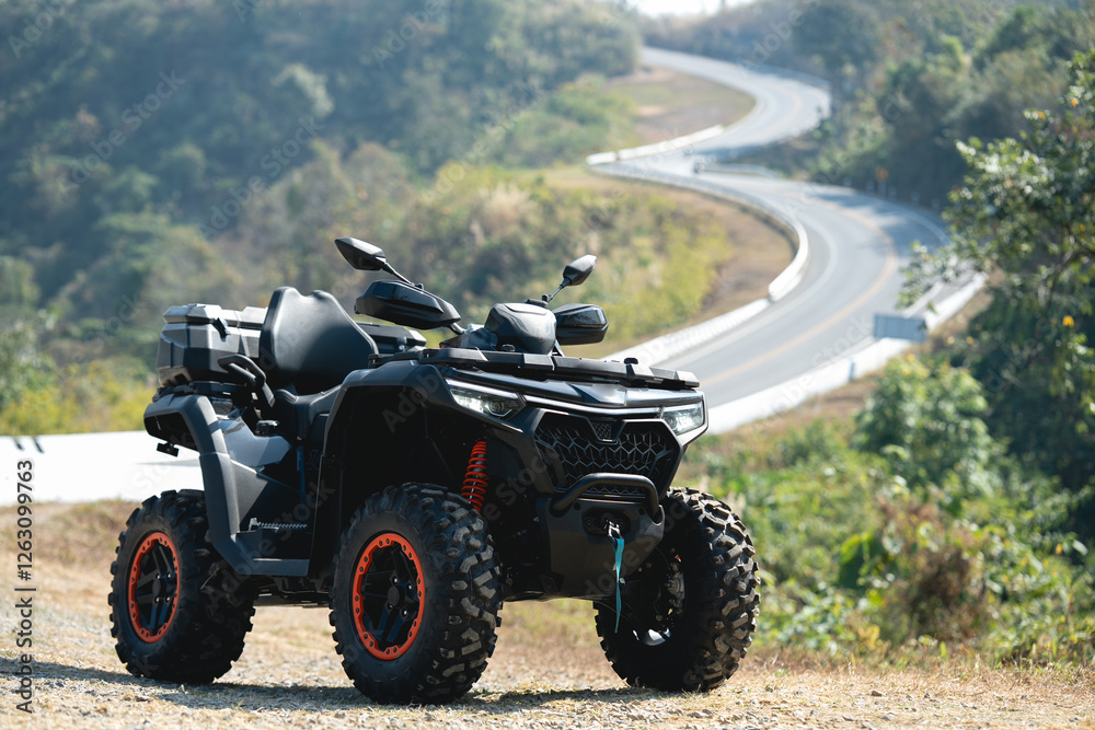 A sleek black ATV parked on a dirt path, surrounded by greenery, with a winding road visible in the distance under a clear sky. A sleek black ATV parked on a dirt path, surrounded by greenery, with a winding road visible in the distance under a clear sky.