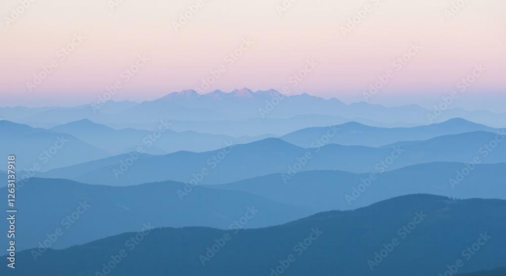 Fototapeta premium Layered Blue Mountain Ranges at Dawn with Soft Hues and Mist
