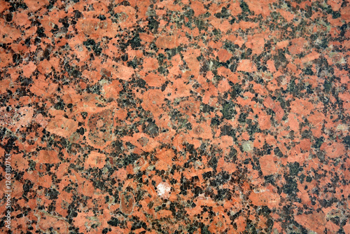 Textured surface of vibrant red granite with intricate patterns