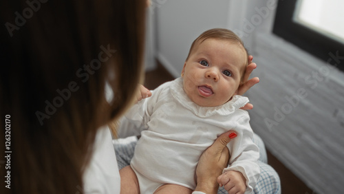 Mother holding baby in cozy indoor setting showcasing warmth and love in a serene home environment filled with family joy.