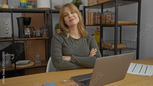 Woman seated with arms crossed in modern office surrounded by shelves and desk items expressing confidence and professionalism in workspace setting.