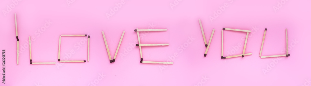 I love you, the inscription is laid out with matches on a pink background. Banner, background with a romantic inscription. I love you, the inscription is laid out with matches on a pink background. Banner, background with a romantic inscription.