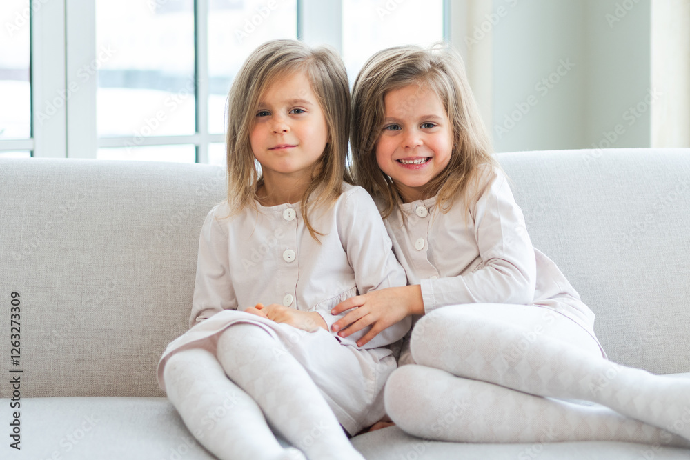 Happy family sisterly love. Two funny little twin sisters girls hugging with love care playing together at home indoors. Happy children lifestyle. Identical twin girls hugs. Girls friendship and youth Happy family sisterly love. Two funny little twin sisters girls hugging with love care playing together at home indoors. Happy children lifestyle. Identical twin girls hugs. Girls friendship and youth