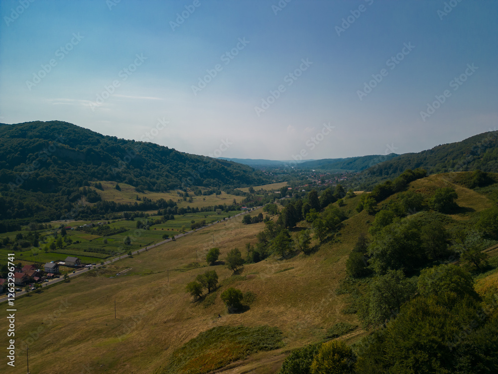 Naklejka premium Picturesque landscape with high hills and forests at the foot of the Carpathian Mountains in sunny weather in summer season