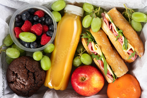 Ready prepared brunch box with sandwiches, fruits, berries and smoothie. Quick lunch break, time saving healthy meal