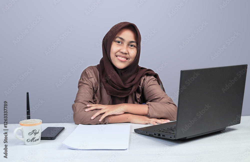 Smiling Muslim Woman Working at Office Desk with Laptop