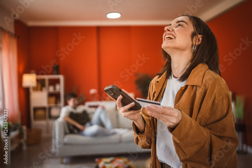 young woman buy online with mobile phone and credit card at home photo