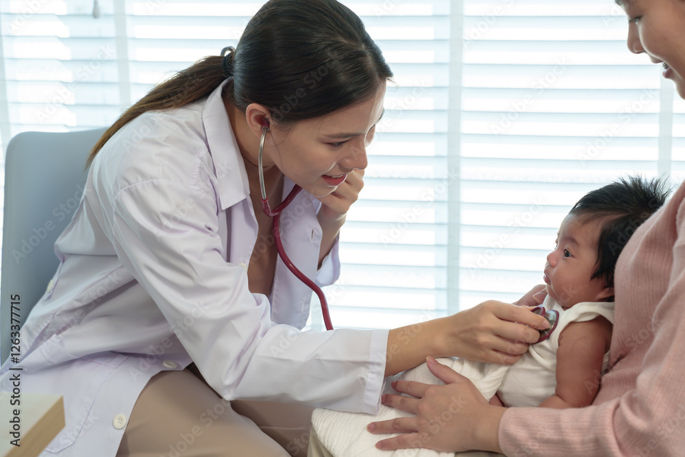 Asian mother brings newborn son to see pediatrician. Female doctor in white coat uses stethoscope to examine infant held by mother. Pediatric checkup ensures baby’s health and well-being. Asian mother brings newborn son to see pediatrician. Female doctor in white coat uses stethoscope to examine infant held by mother. Pediatric checkup ensures baby’s health and well-being.