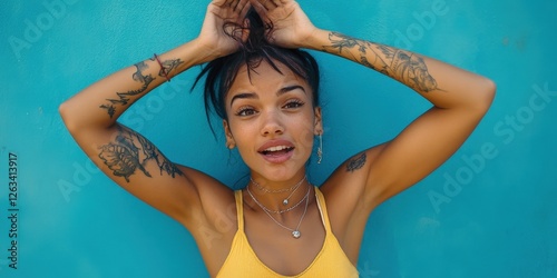 Close-up of a woman in a vibrant yellow tank top, showcasing intricate black tattoos adorning her arms, exuding elegance and artistic flair photo