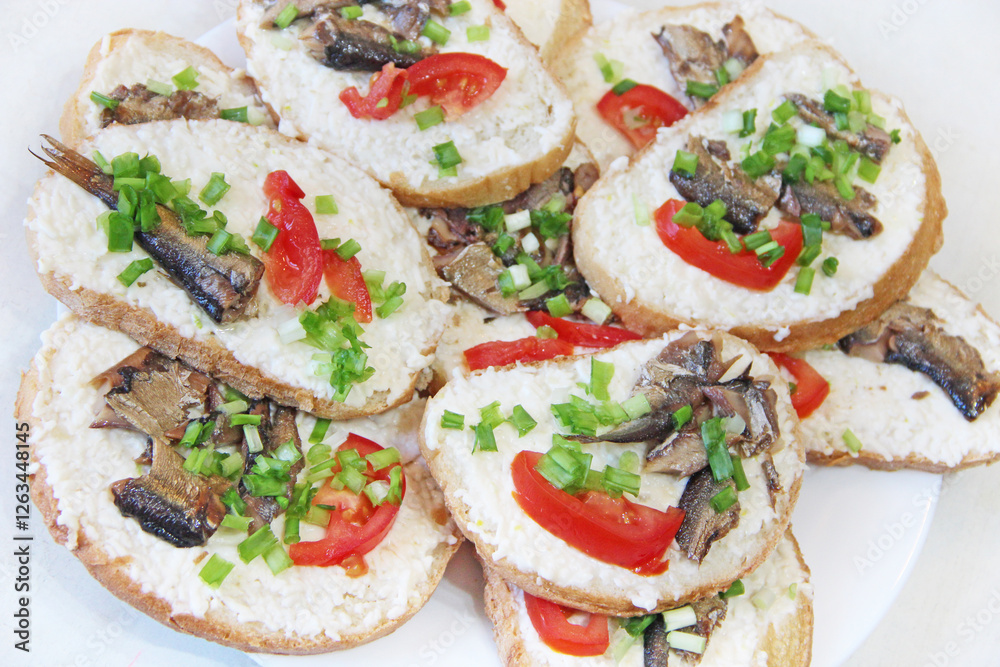toasts with sprats and green onions on plate. Cold appetizers. Sandwiches toasts with sprats and green onions on plate. Cold appetizers. Sandwiches