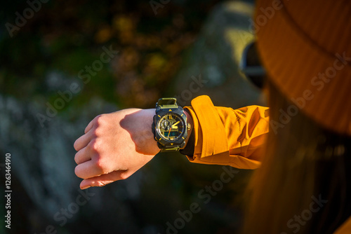 Over the shoulder view of Female Checking Current Altitudeon Casio Wrist Watch While Exploring a Cave in a Canyon
